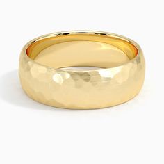 a yellow gold wedding ring on a white background, with the top half slightly closed