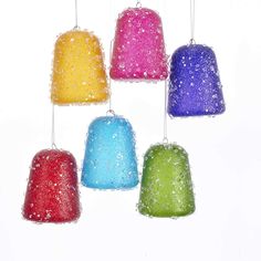 six different colored bell ornaments hanging from strings