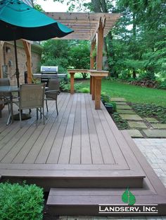 a deck with an umbrella and chairs under it