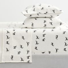 three pillows and two pillow cases on top of each other with black cats printed on them