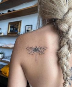 a woman with a dragonfly tattoo on her back