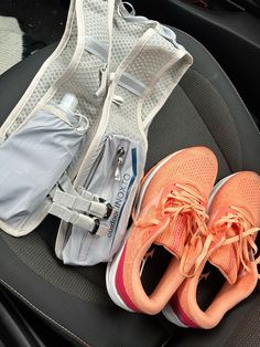 two pairs of running shoes sitting on top of a car seat next to a backpack