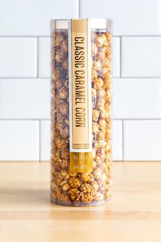 a glass jar filled with popcorn sitting on top of a wooden table