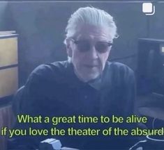 an old man wearing sunglasses sitting at a desk