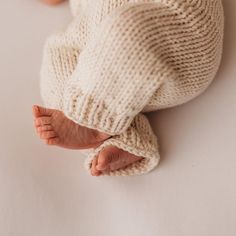 a baby's feet in a white knitted blanket