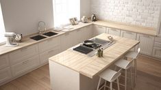 a kitchen with white cabinets and an island in the middle is seen from across the room