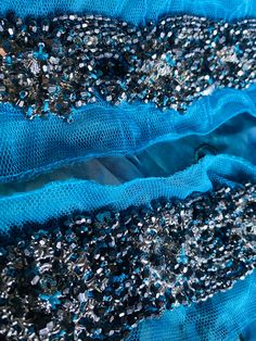 This gorgeous applique makes the perfect start to a black tie gown or Greek Goddess dress! Beautiful silver beads are hand sewn onto a turquoise lace mesh. Sold by the piece. Blue Beaded Fitted Sequin Fabric, Blue Beaded Sequin Fabric, Fitted Blue Beaded Sequin Fabric, Glamorous Blue Embellished Sequin Fabric, Embellished Blue Sequin Fabric For Prom, Blue Embellished Sequin Fabric For Prom, Blue Beaded Lace Sequin Fabric, Elegant Blue Beaded Sequin Fabric, Greek Goddess Dress