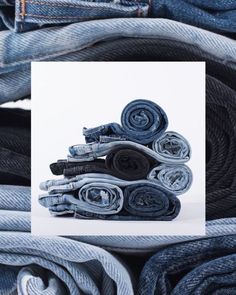 several rolled up jeans stacked on top of each other