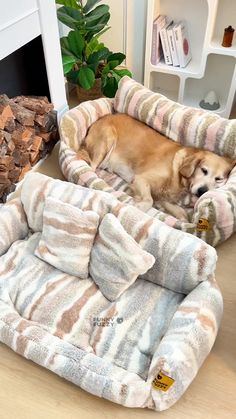 a dog laying on top of a bed next to a pile of firewood in a living room