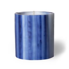 a blue candle is sitting on a white surface