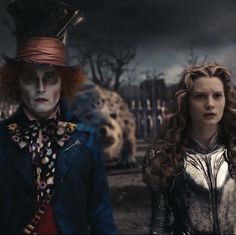 two people dressed in costumes standing next to each other on a dark background with clouds