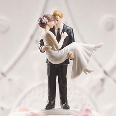 a bride and groom figurine on top of a wedding cake