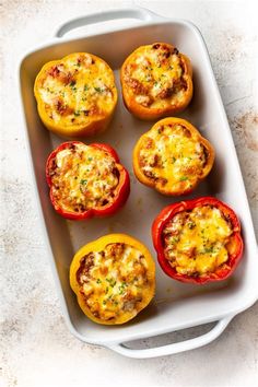 six stuffed peppers in a baking dish on a counter top, ready to be eaten