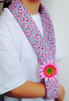 a woman wearing a white t - shirt holding a pink flower