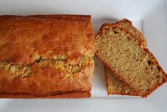 a loaf of banana bread next to another loaf on a white plate with one slice cut off