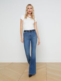 A vintage-inspired bell-bottom jean in medium blue with classic fading and whiskering. Premium stretch denim in a light blue hue has a contoured waistband that fits securely around the natural waist as it smooths and slims, while the premium stretch denim hugs hip, thigh, and fitted through the knee before releasing into a sleek straight leg which can be altered up to 4" without drastically changing the shape. | L'AGENCE Bell Flare Jean In Authentique Bell Jeans, Denim Blouse, Light Wash Denim, High Rise Jeans, Light Denim, Denim Coat, Premium Denim, Bottom Clothes, Medium Blue