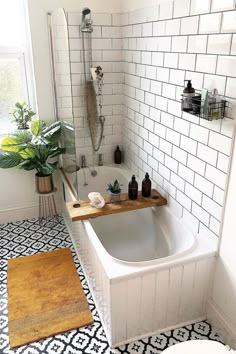 a white bathroom with black and white tile flooring, a bathtub in the middle