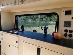 an apple is sitting on top of the counter in front of a window that overlooks a lake