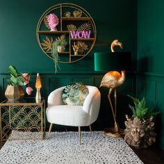 a living room with green walls, gold accents and flamingos on the side table