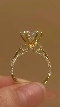 a hand holding a yellow gold ring with diamonds on it's sidestrap