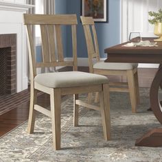 a dining room table with two chairs and a rug