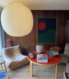 a living room filled with furniture and a large painting on the wall above it's windows