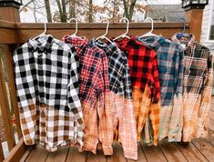 several shirts hanging on a clothes rack outside