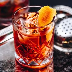 a close up of a drink in a glass with an orange slice on the rim