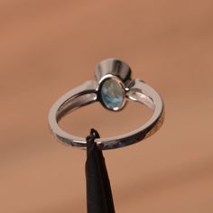 It is a Swiss blue topaz ring. The main stone is 6 mm*8 mm oval cut.weight about 1.47 carats. The basic metal is sterling silver and plated with rhodium. To change the metal to a solid gold (white/rose) or platinum is also available, please ask for a quotation if you want. You can also go to my shop Home for more elegant rings: https://www.etsy.com/shop/godjewelry?ref=hdr_shop_menu Swiss blue topaz is the November birthstone . More Swiss blue topaz rings: https://www.etsy.com/shop/godjewelry?sea Oval Aquamarine Ring With Bezel Setting, Oval Aquamarine Birthstone Ring Fine Jewelry, Silver Oval Aquamarine Birthstone Ring, Oval Topaz Jewelry With Polished Finish, Silver Aquamarine Oval Birthstone Ring, Oval-shaped Polished Topaz Jewelry, Silver Aquamarine Birthstone Ring, Oval Shape, Silver Aquamarine Birthstone Ring, Oval Cut, Oval Aquamarine Birthstone Ring