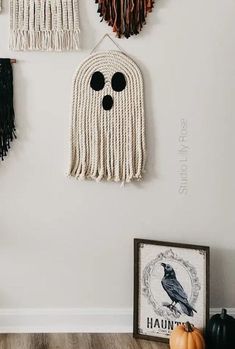 three wall hangings decorated with macrame, feathers and black eyeballs on them