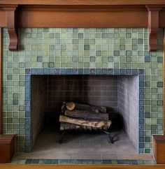 an old fireplace with green tiles and wood