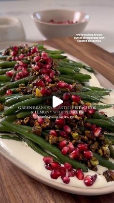 green beans and pomegranate on a white plate