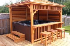 an outdoor hot tub on a deck with stools and table next to the hot tub