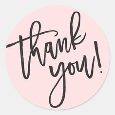 the words thank you are written in black ink on a pink round sticker that says,