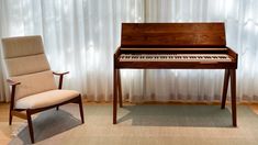 a chair and piano in front of a window