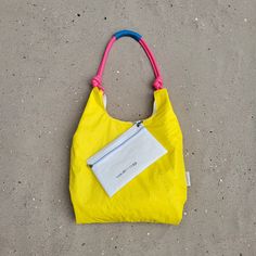 UNIQUE A women's handbag made of a light spinnaker sail in yellow lemon color. The blue Dacron sail lining gives the handbag better stability. 100% RECYCLING SAILS All the sails used to sew women's handbags are recycled. We buy them and receive them from sailors from all over Europe. Natural leather of the highest quality is obtained from leftovers from mass production. HANDMADE IN EUROPE We create handbags in our small manufacturer in Poland. We use components produced only in Europe: zippers, Yellow Nylon Bag For Outdoor, Eco-friendly Yellow Shoulder Bag For Travel, Yellow Tote Bag For Outdoor, Functional Yellow Nylon Bag, Functional Yellow Bag For Outdoor, Functional Yellow Bags For Outdoor, Functional Yellow Outdoor Bag, Functional Yellow Outdoor Bags, Eco-friendly Yellow Beach Bag For Everyday Use