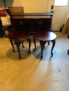 two wooden tables sitting next to each other in front of a dresser and mirror on the floor