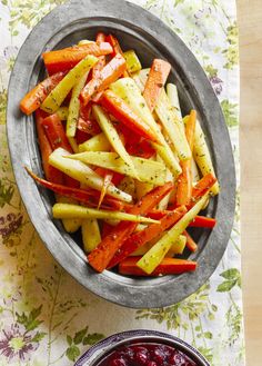 carrots and cranberry sauce in a bowl on a floral tablecloth next to a spoon