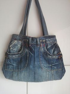 an old pair of jeans is hanging on the wall with a purse attached to it