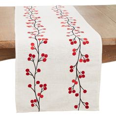 a white table runner with red berries on it