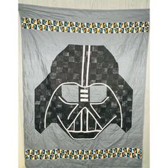 a star wars themed quilt with a darth vader helmet on it's side