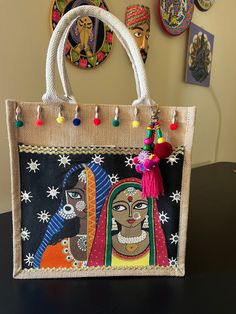 Beautiful Rajasthani women hand painted on a jute bag with fabric paints and adorned with Pom Pom tassels. Bohemian Multicolor Canvas Bag, Bohemian Jute Bag As Gift, Festival Bags With Tassels As Gifts, Bohemian Jute Bag With Tassels, Bohemian Shoulder Bag With Tassels As Gift, Bohemian Shoulder Bag With Tassels For Gift, Painting On Jute Bags, Handmade Multicolor Jute Shoulder Bag, Traditional Jute Bags As Gifts