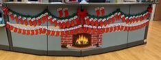 a christmas themed counter with stockings hanging from the front and fireplace in the back,