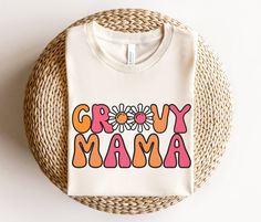 a white t - shirt with the words grooy mama printed on it next to a wicker basket