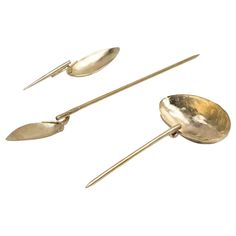 three gold spoons and two forks on a white background