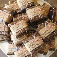 chocolate brownies wrapped in twine and labeled with spanish words are on a plate