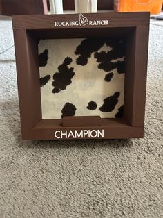 the box is made out of wood and has a cow print on it