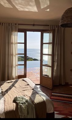 a bedroom with an open door leading to the ocean