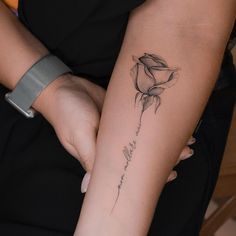 a woman's arm with a rose tattoo on it and the words love is written in cursive writing