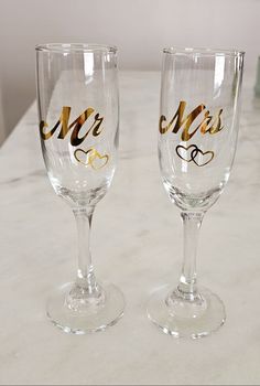 two wine glasses with the word mr and mrs painted on them sitting next to each other